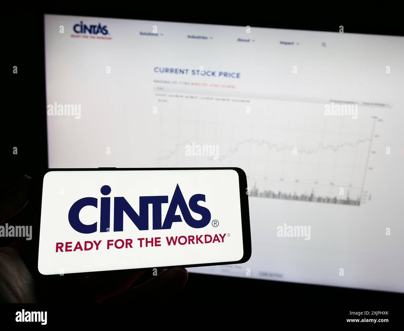 Stuttgart, Germany : 06-25-2023: Person holding mobile phone with logo of Aemrican company Cintas Corporation on screen in front of business web Stock Photo