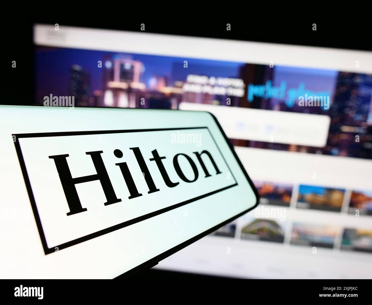 Stuttgart, Germany, 07-02-2023: Cellphone with logo of American company Hilton Worldwide Holdings Inc. on screen in front of website. Focus on Stock Photo