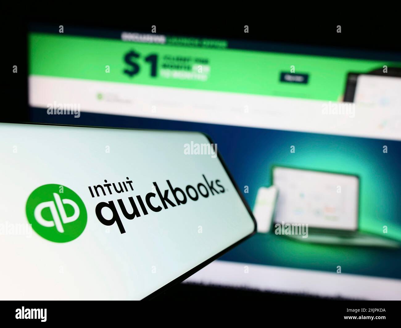 Stuttgart, Germany, 07-09-2023: Mobile phone with logo of accounting software QuickBooks on screen in front of business website. Focus on center-left Stock Photo