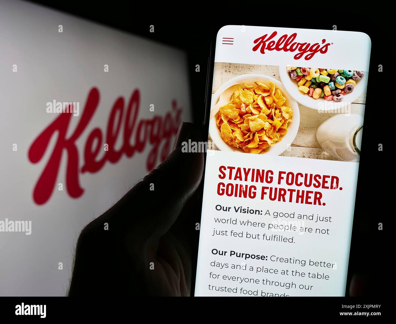 Stuttgart, Germany, 07-29-2023: Person holding cellphone with website of US business The Kellogg Company (Kellogg's) on screen in front of logo. Stock Photo