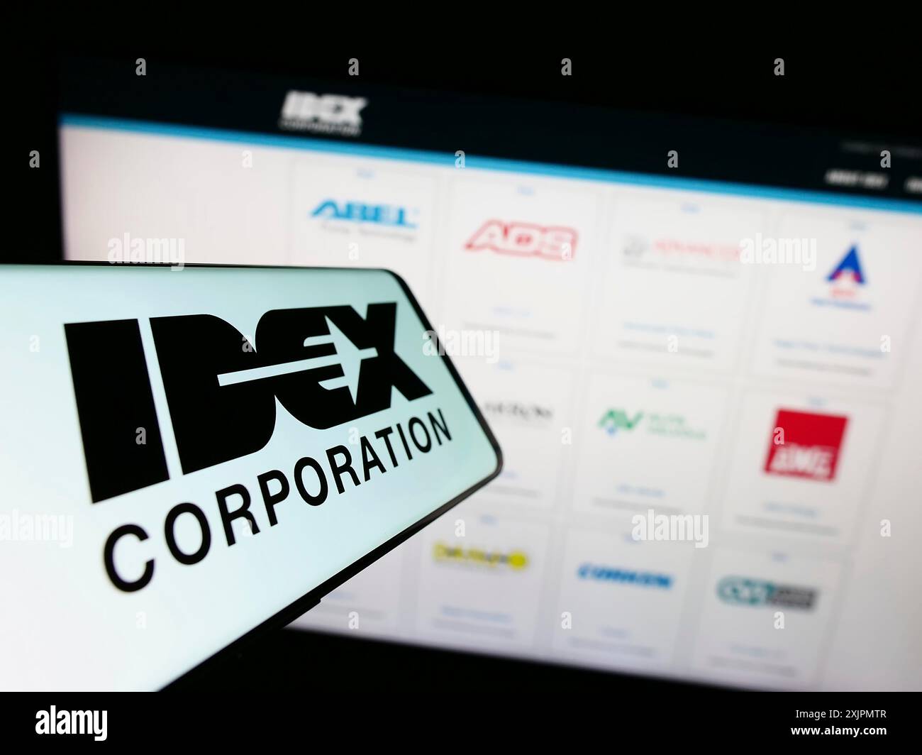 Stuttgart, Germany, 07-29-2023: Smartphone with logo of American manufacturing company IDEX Corporation on screen in front of website. Focus on Stock Photo