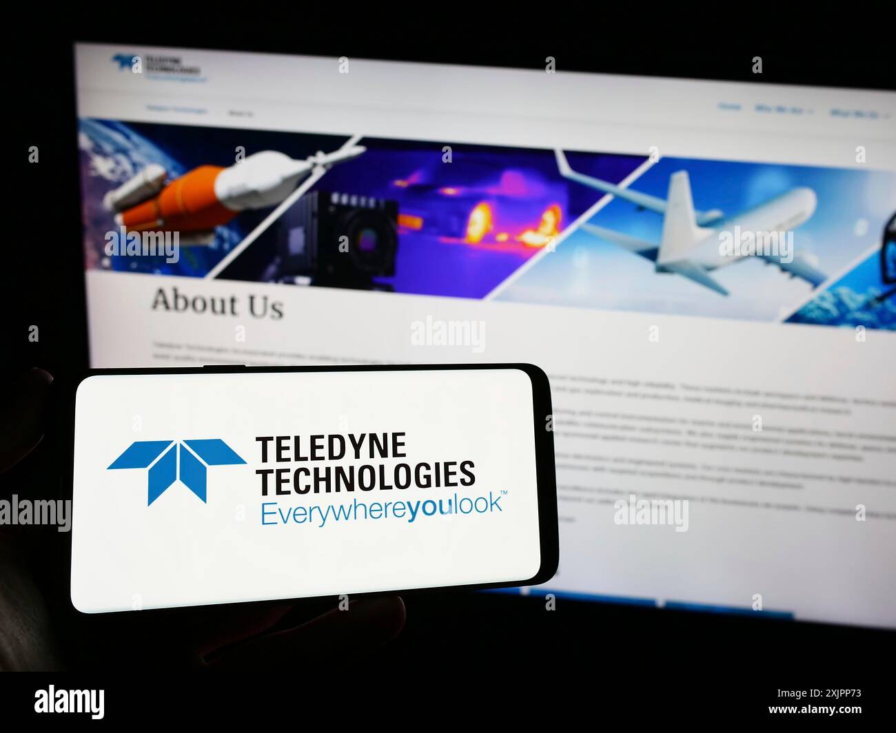 Stuttgart, Germany, 08-09-2023: Person holding smartphone with logo of US company Teledyne Technologies Incorporated on screen in front of website. Stock Photo