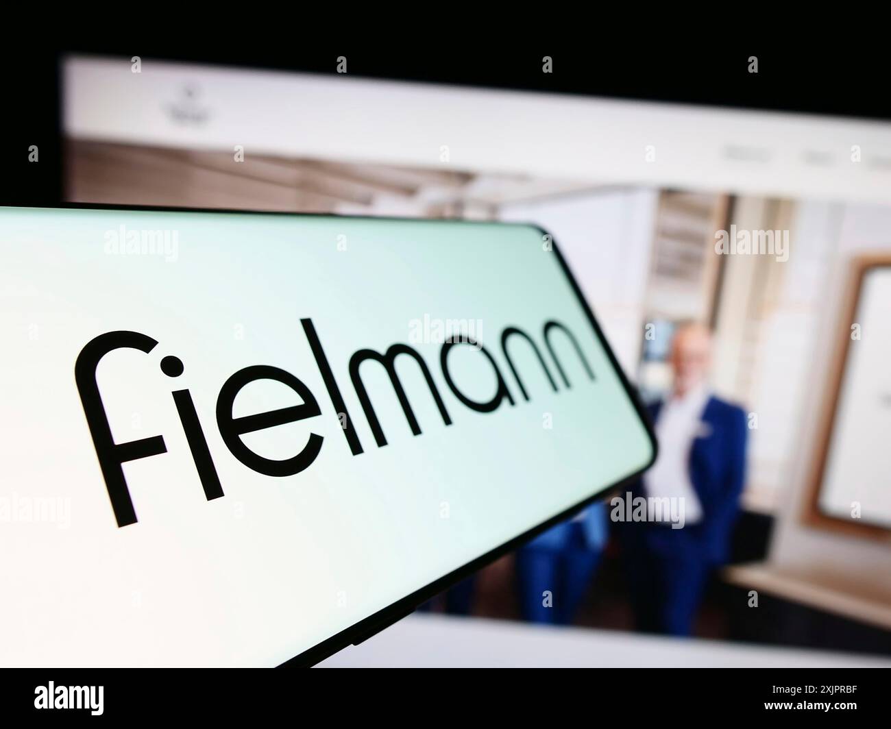 Stuttgart, Germany, 08-21-2023: Smartphone with logo of German eyewear company Fielmann AG on screen in front of business website. Focus on left of Stock Photo