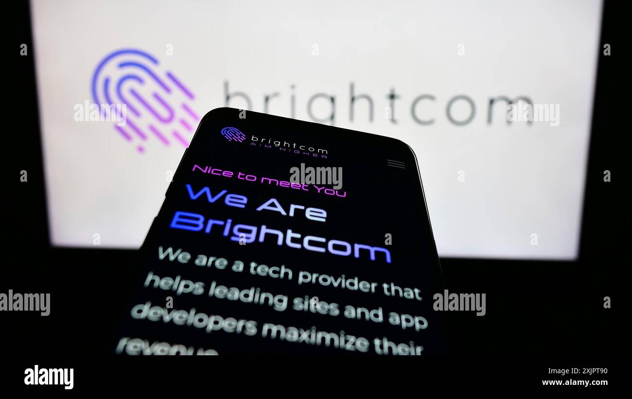 Stuttgart, Germany, 09-05-2023: Mobile phone with webpage of digital marketing company Brightcom Group on screen in front of business logo. Focus on Stock Photo