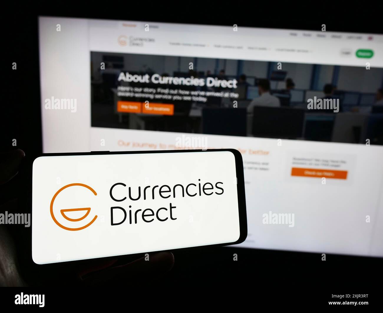 Stuttgart, Germany, 12-23-2023: Person holding smartphone with logo of British money transfer company Currencies Direct Ltd. in front of website. Stock Photo
