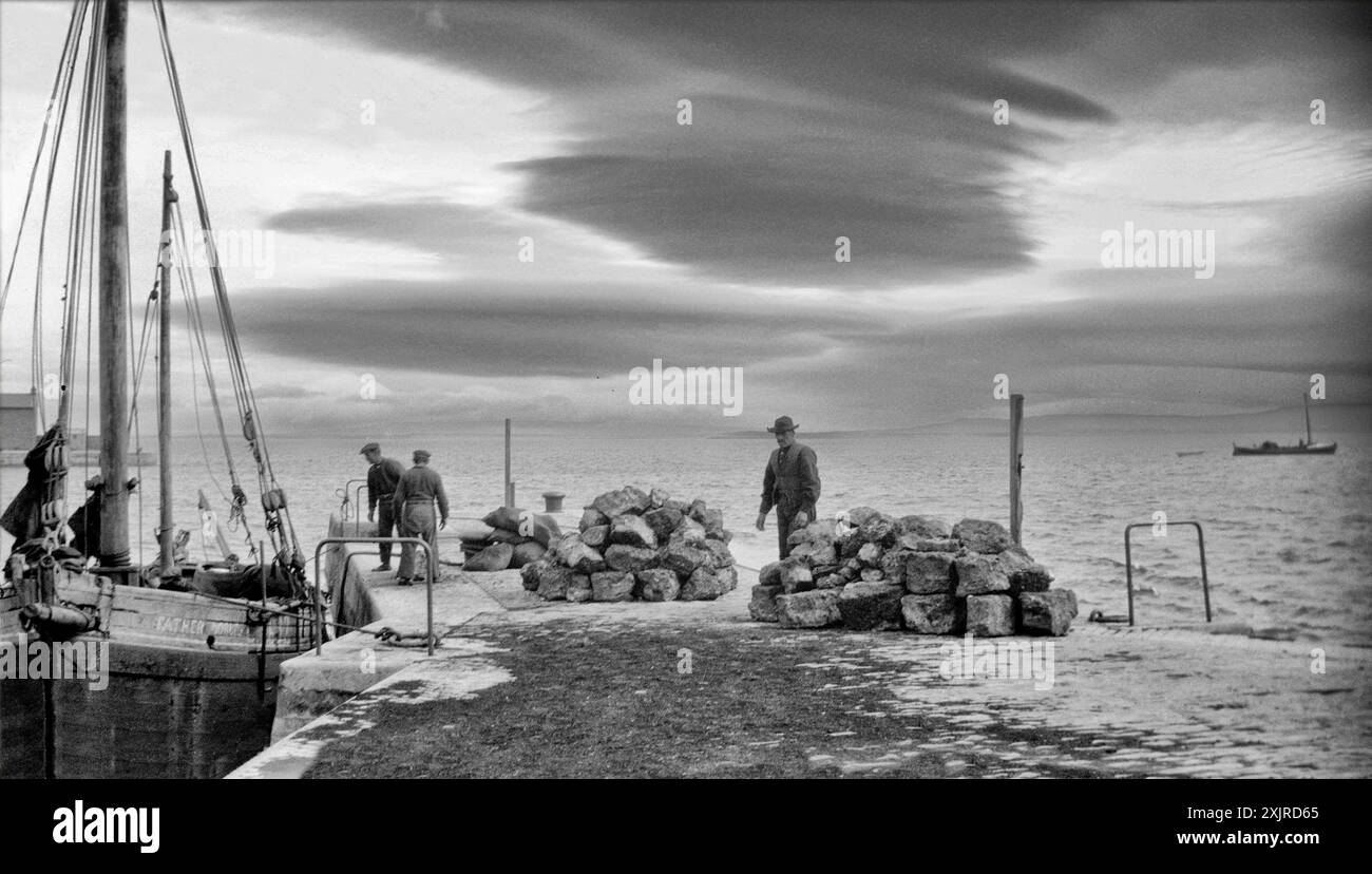 Islanders loading iodine from the quays on the Aran Islands, County Galway, Ireland. Photographed by Ellen O'Connor (1874-1943) in 1927. Stock Photo