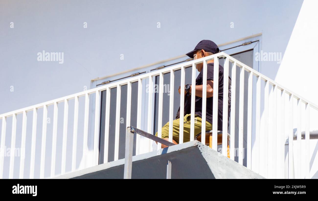 People on the balcony a with white building Stock Photo - Alamy