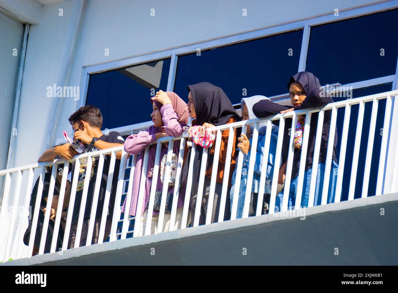 People on the balcony a with white building Stock Photo - Alamy