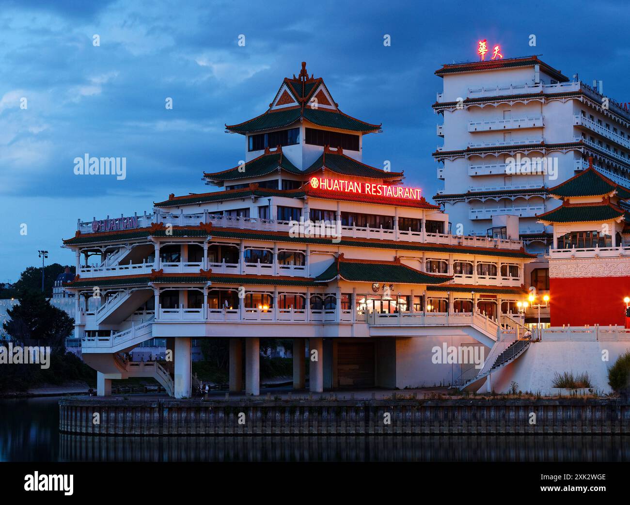 The night view of the chinese-inspired architecture of the Huatian Chinagora restaurant with curved roof corners and traditional glazed roof tiles. Stock Photo