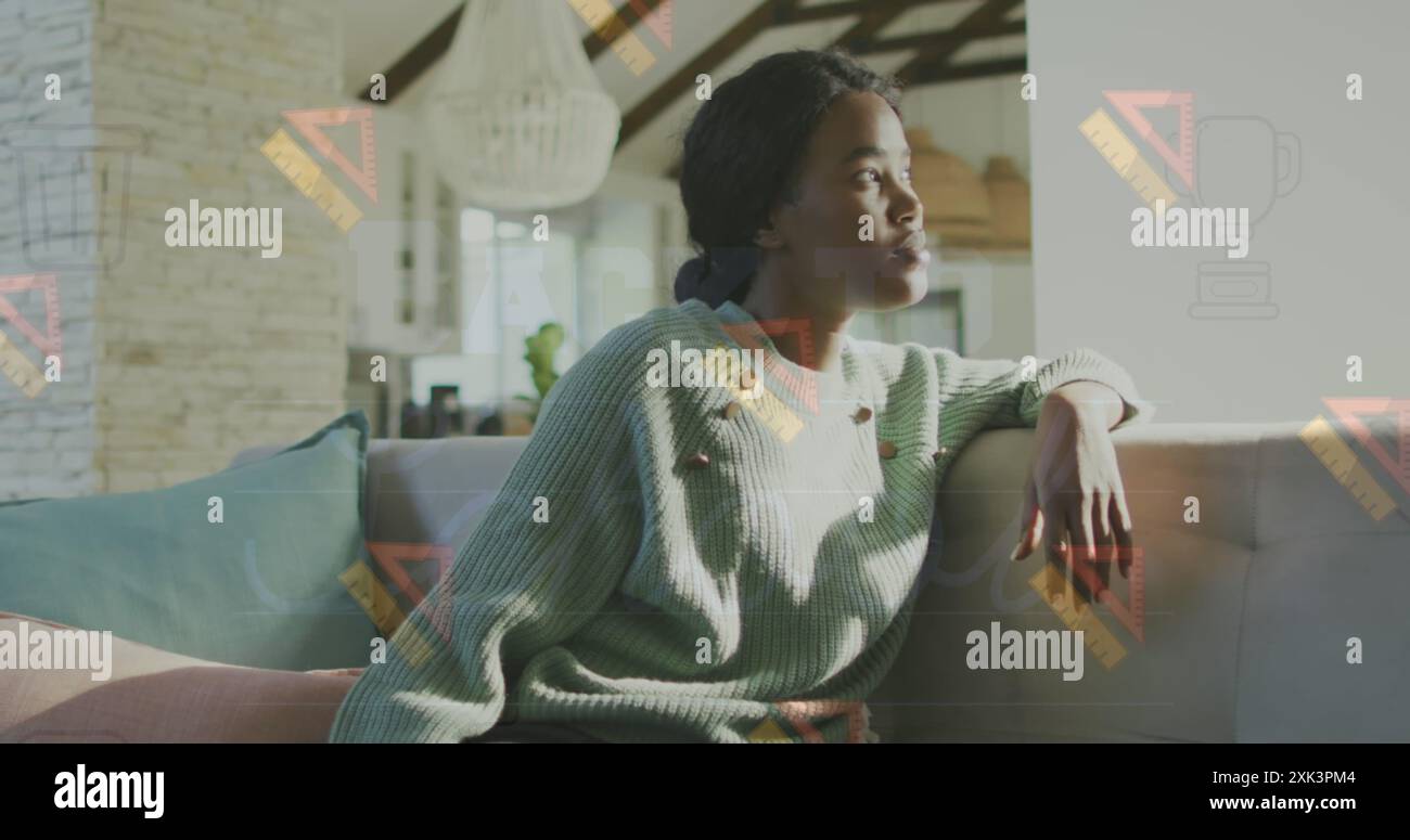 The image shows a thoughtful african american woman sitting on a sofa ...