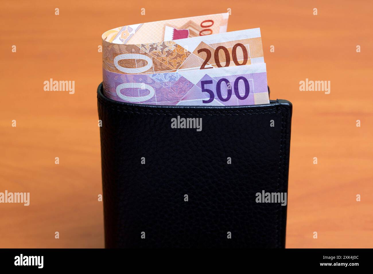 Qatari money - riyal in the black wallet Stock Photo - Alamy