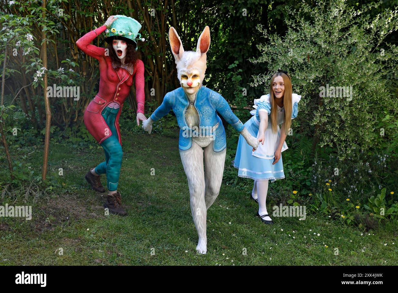 GEEK ART - Bodypainting and Transformaking: Alice in Wonderland photoshooting with Melina as Alice, Julia as the Mad Hatter and Janina as the White Rabbit in the Czarnecki Garden in Hameln. - A project by photographer Tschiponnique Skupin and bodypainter Enrico Lein Stock Photo