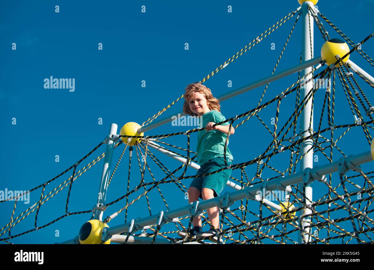 Kid boy playing on the rope outdoor playground Stock Photo - Alamy