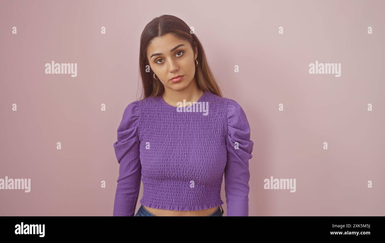 Hispanic Poses A young hispanic woman with attractive features poses against a pink ...