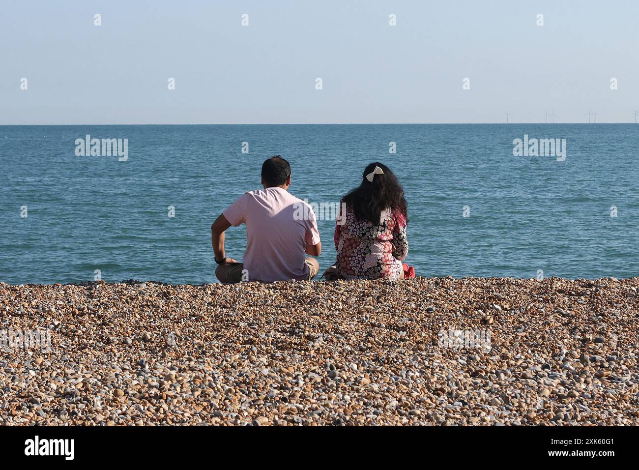 A couple sitting on Brighton beach Stock Photo