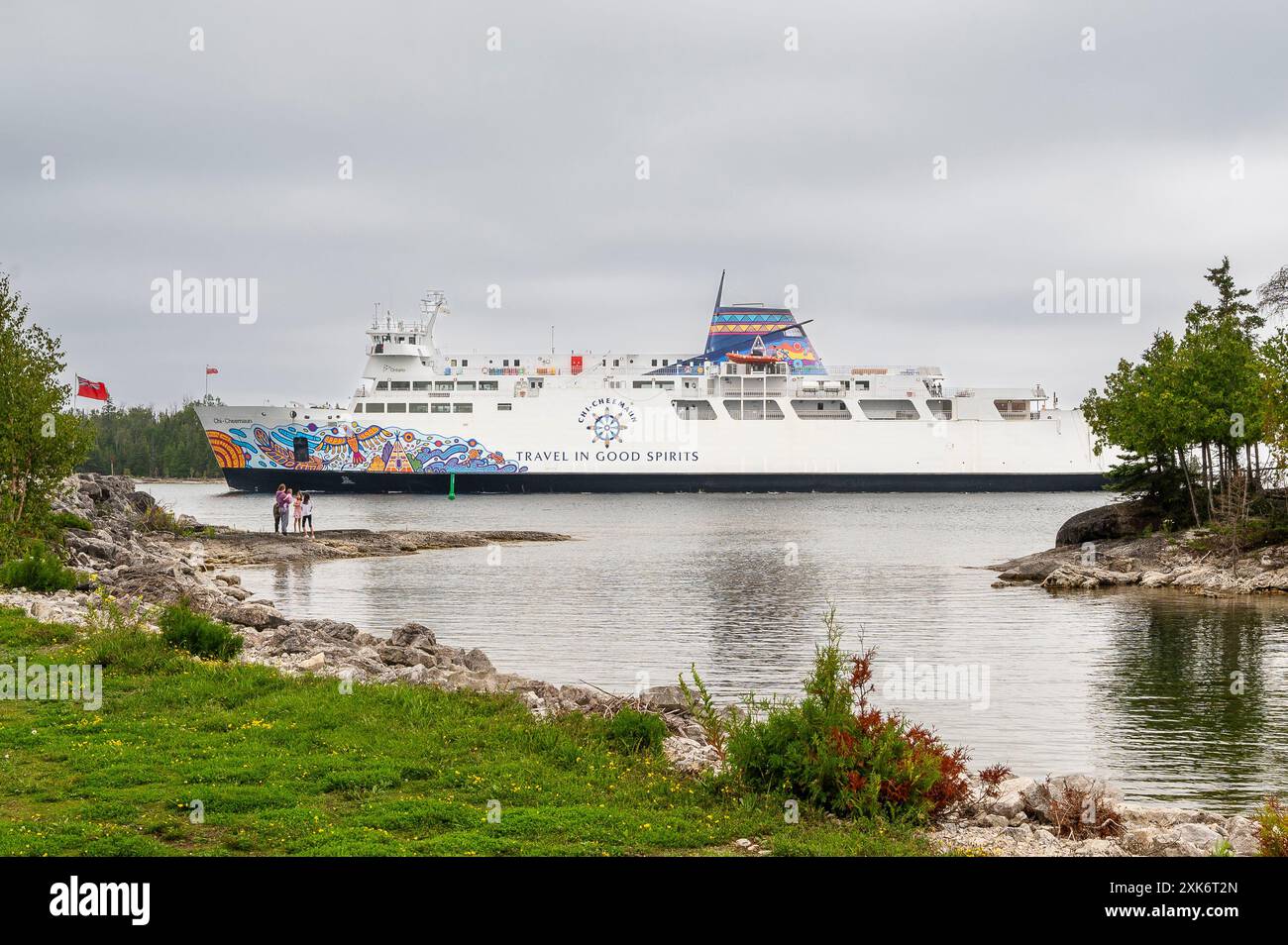 Chi-Cheemaun Ferry Coming into South Baymouth from Tobermory with some tourists on the shoreline watching. Stock Photo