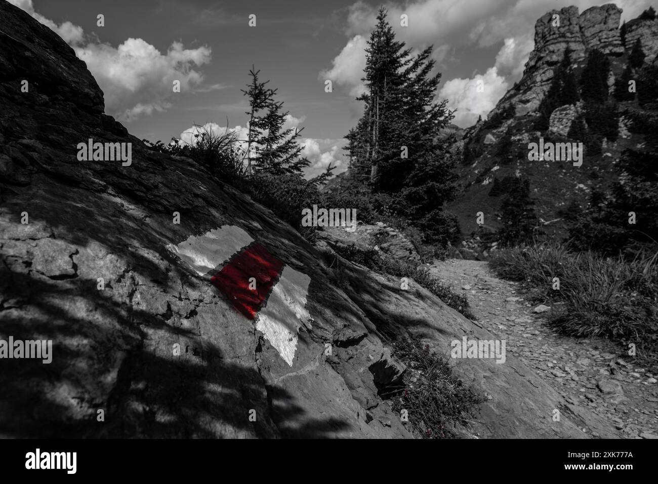 Red and white hiking sign, with mountains in a blurred background, shot on the Schynigge Platte near Interlaken, Bern, Switzerland Stock Photo