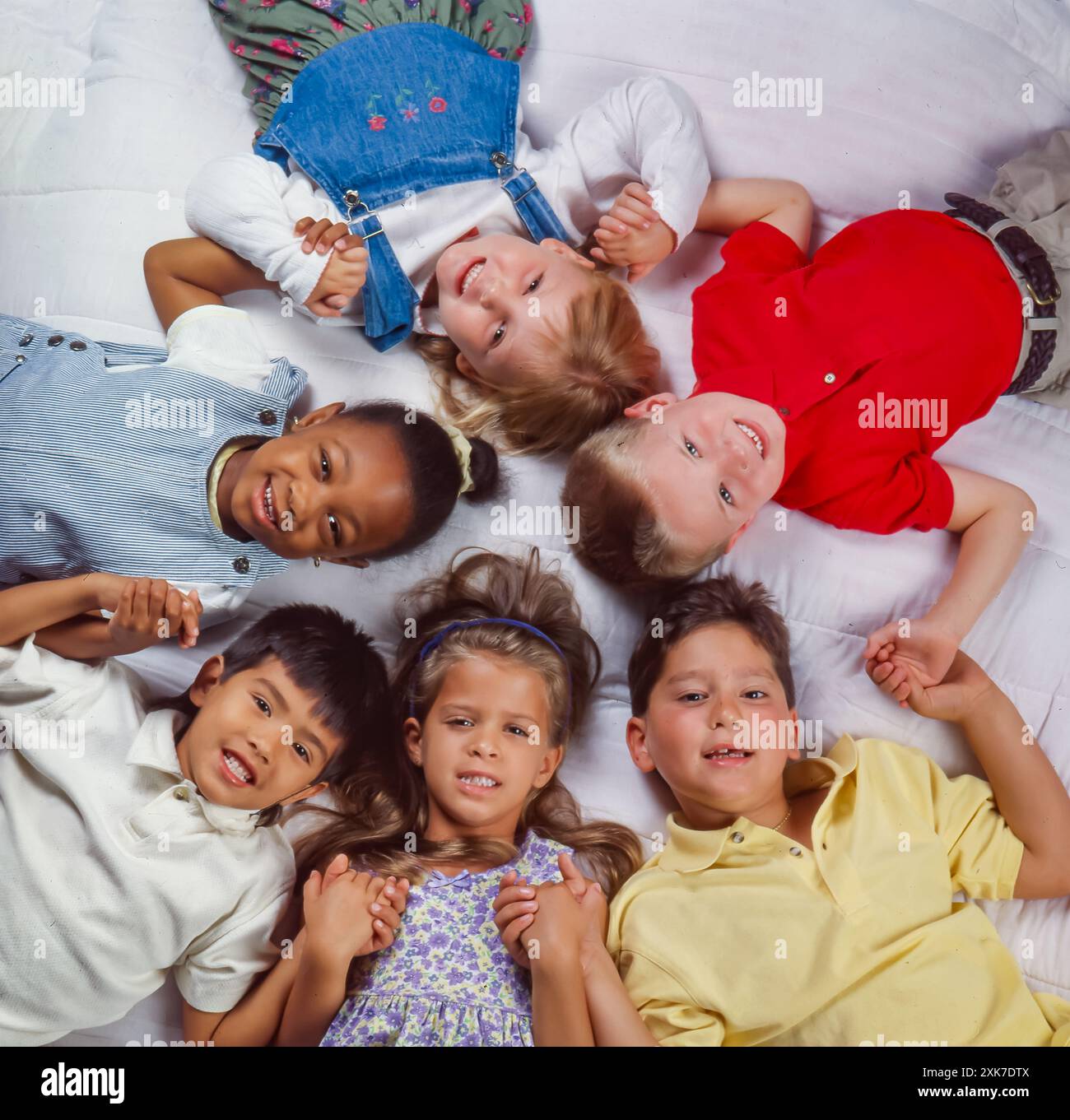 Overhead view of diverse group of young children holding hands in a ...