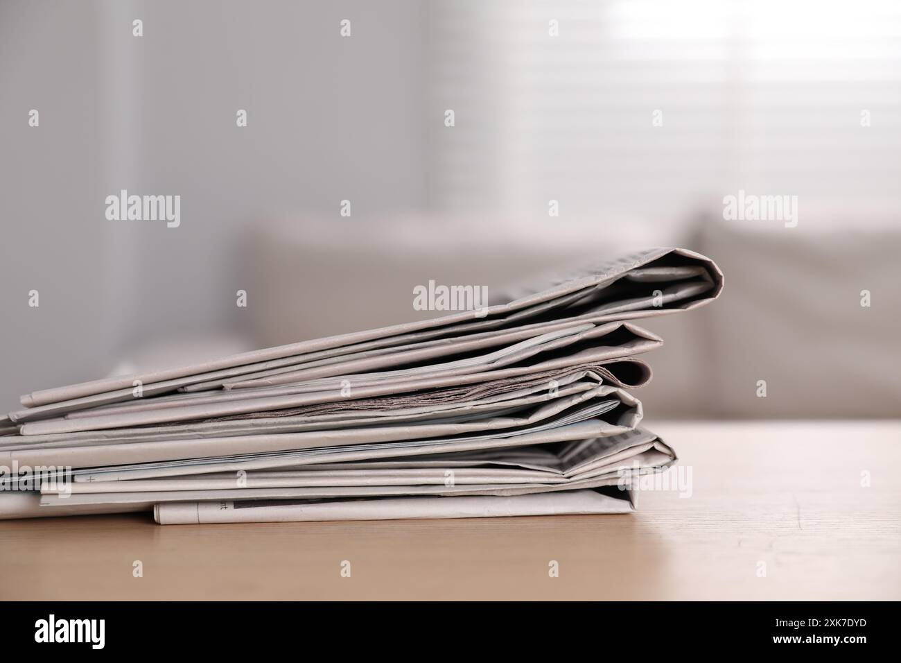 Stack of newspapers in different languages on table indoors Stock Photo