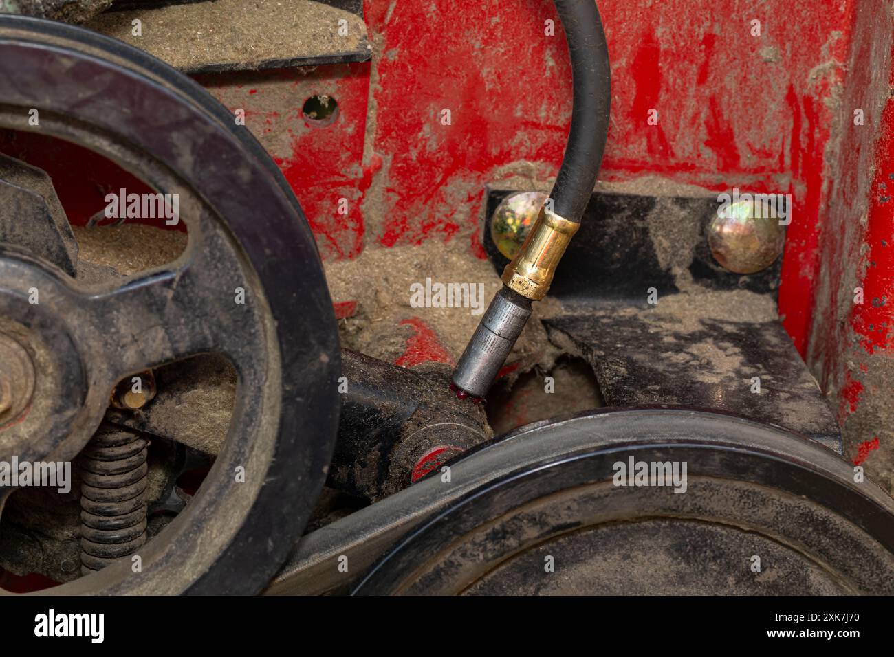 Greasing equipment on combine harvester. Farming equipment routine maintenance, repair and machinery lubrication concept. Stock Photo