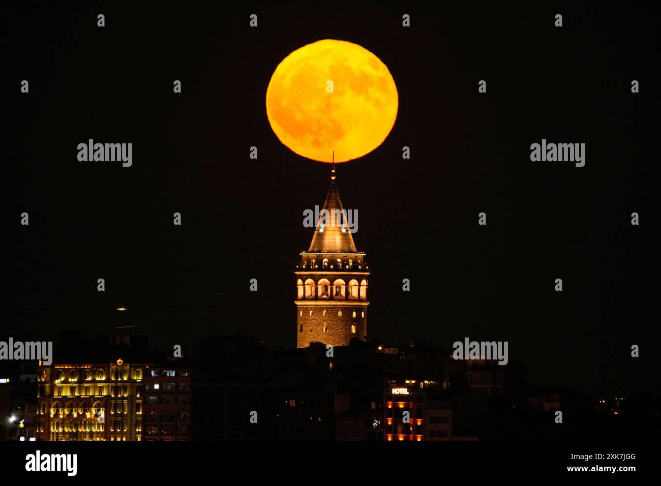 A full moon rises behind Galata Tower landmark in Istanbul Sunday, July ...