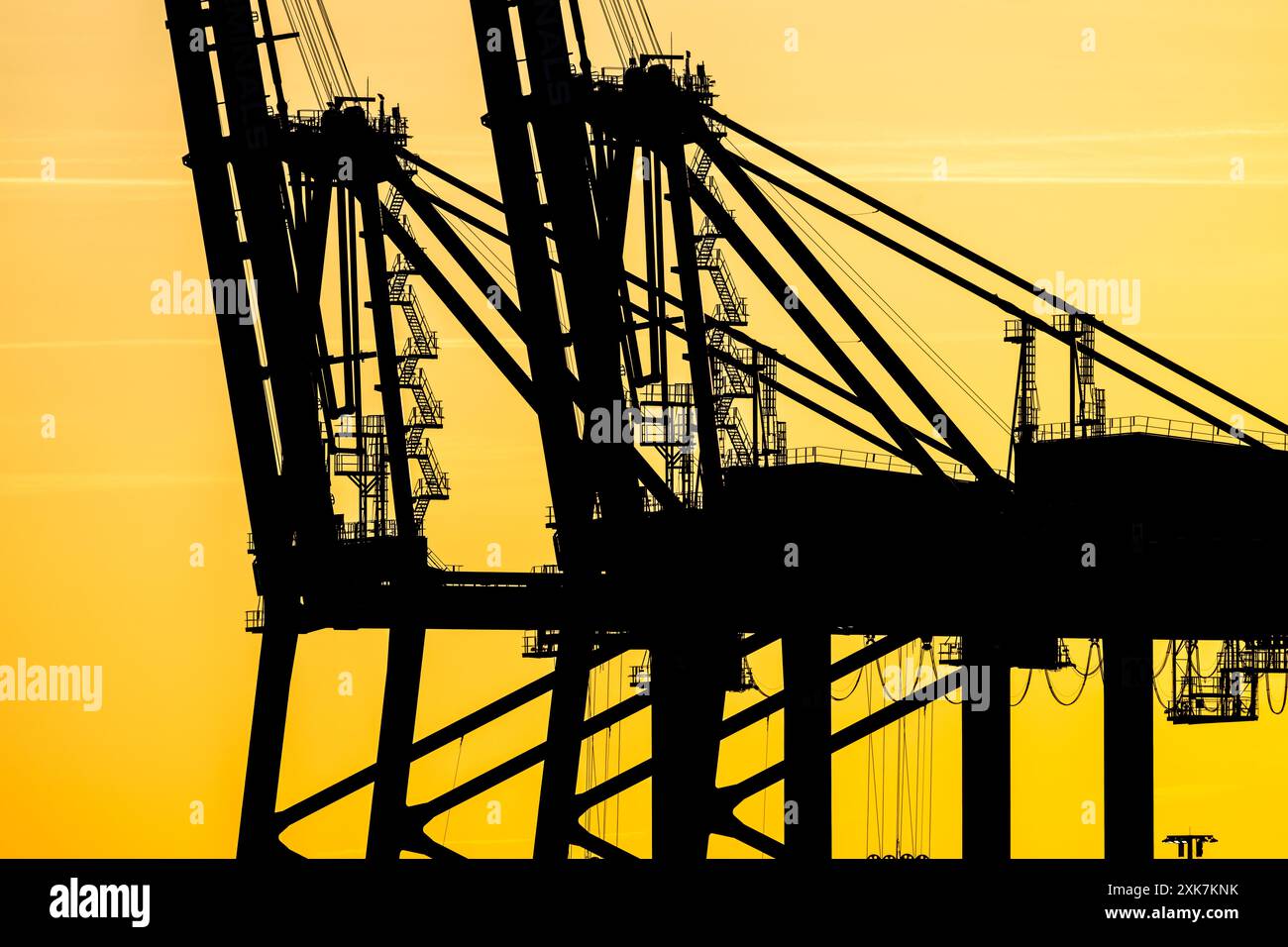 Sunset silhouette of container ship loading cranes Stock Photo - Alamy