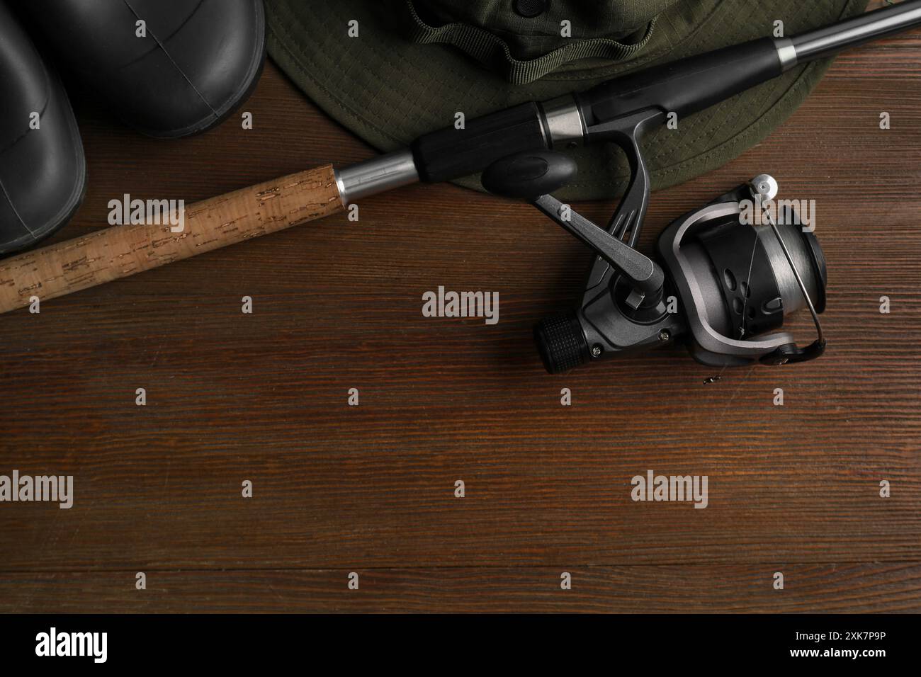 Fishing Rod Boot Fishing rod with spinning reel, hat and boots on wooden table, top view ...