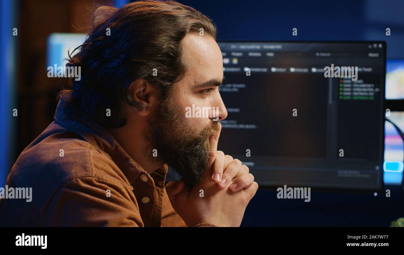 Cheerful software technician feeling satisfied after removing all bugs while coding on computer, close up. Smiling IT expert looking at screen, happy after solving script errors, camera A Stock Photo