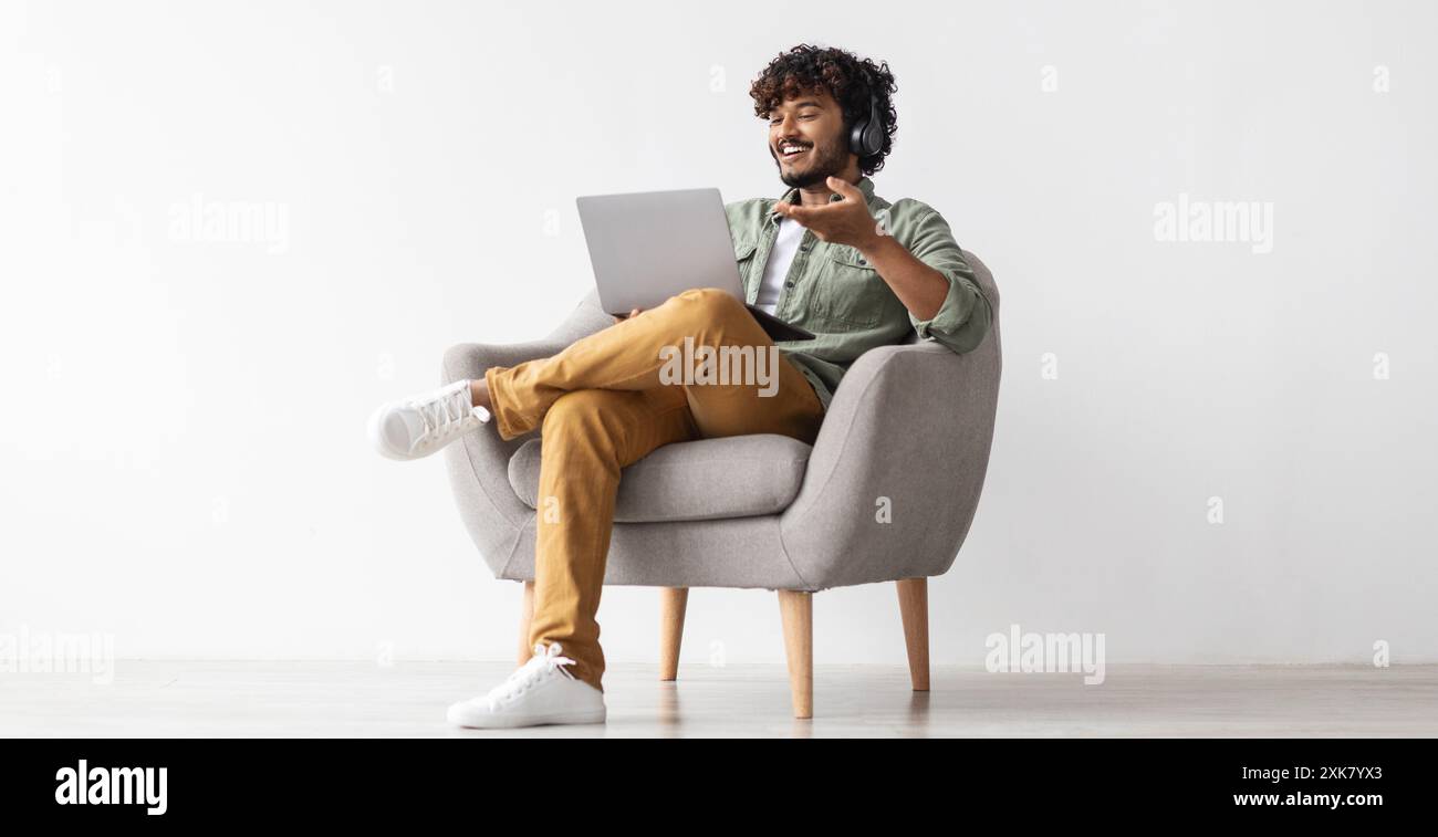 Positive handsome indian having video conference, using notebook Stock Photo