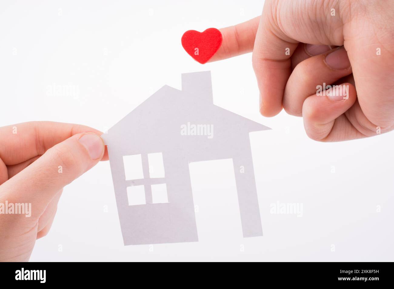 Paper house and heart shape in hand on a white background Stock Photo ...