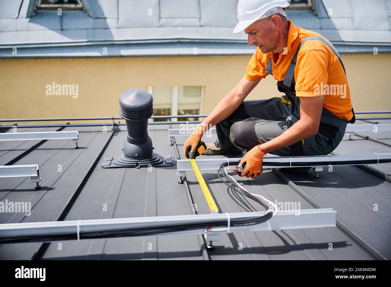Worker building solar panel system on rooftop of house for generating ...