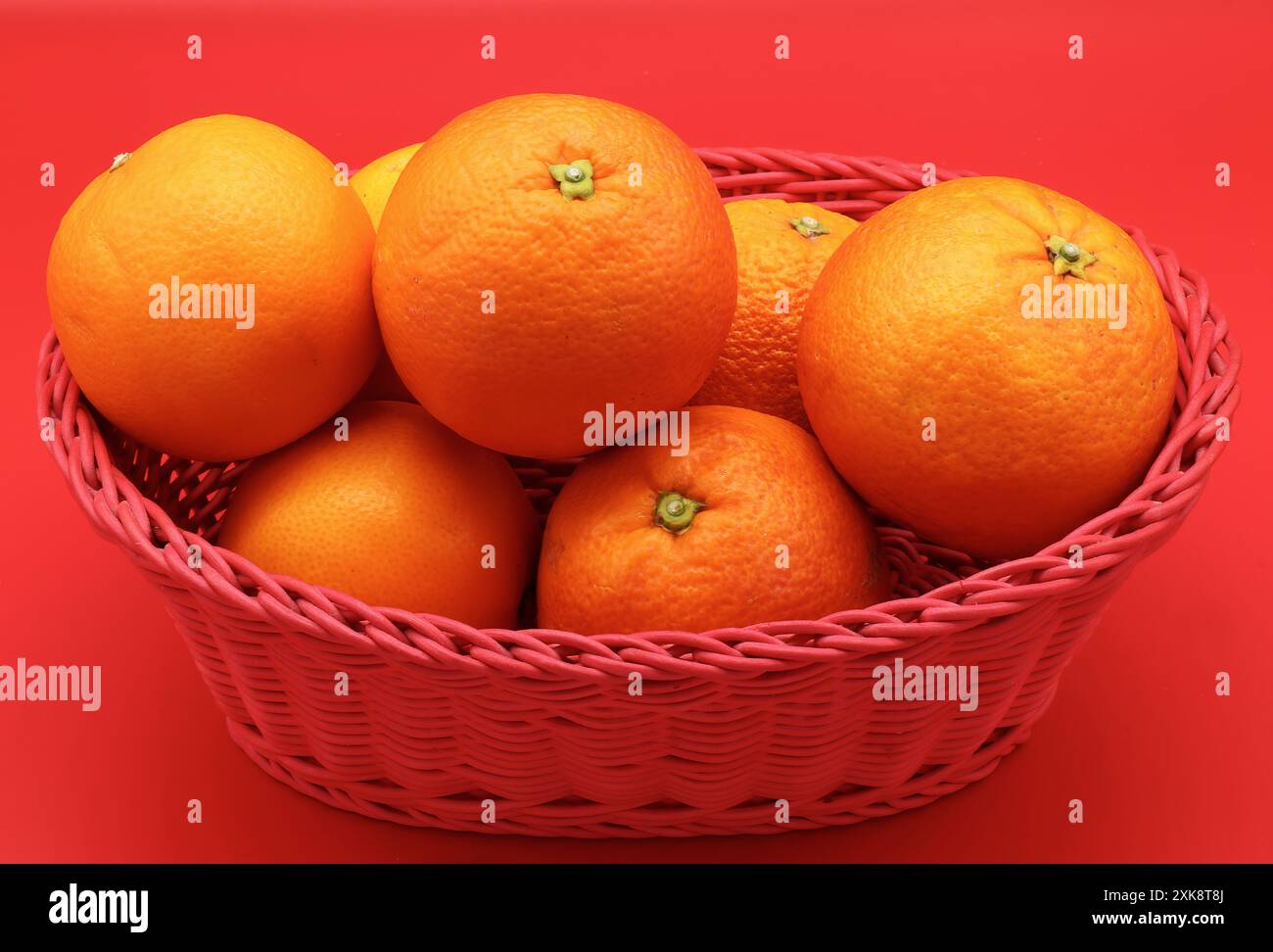 Fresh oranges isolated on red background. Stock Photo
