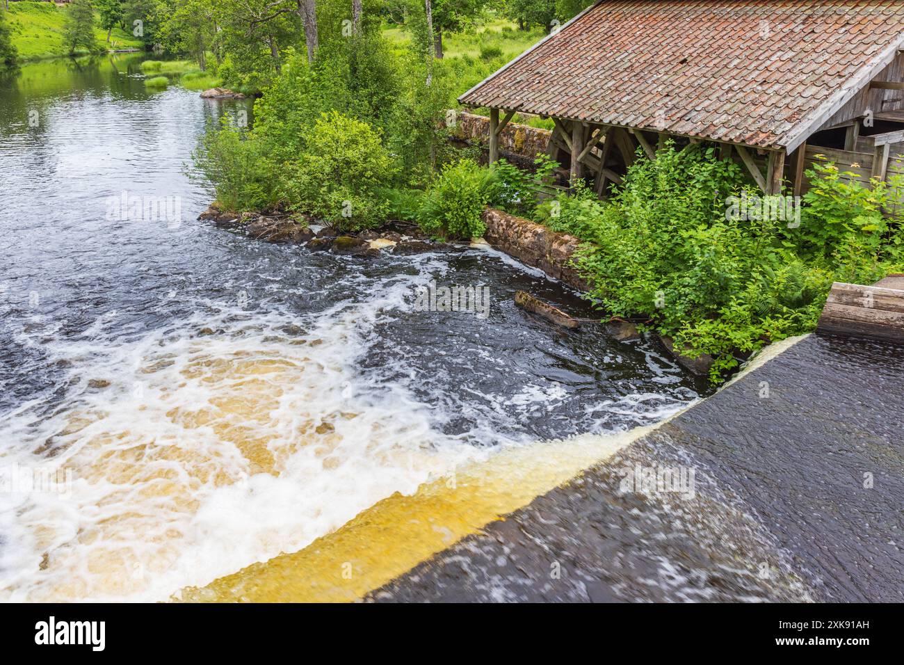 Flowing water in a pond and a mill Stock Photo