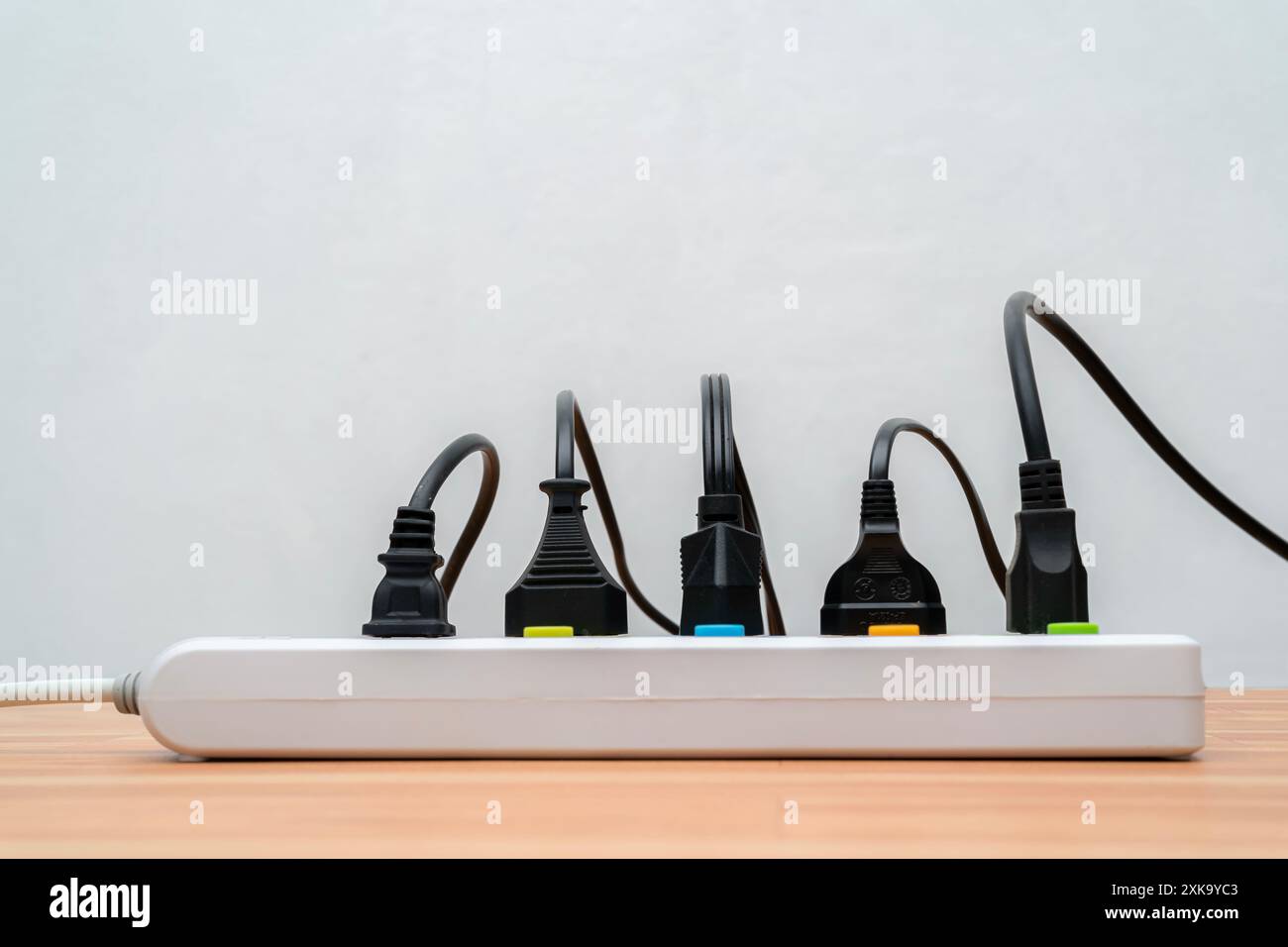Many plugs connected to the power strip with individual switches. Surge protector with connected white wires of electrical appliances. Free space. Soc Stock Photo