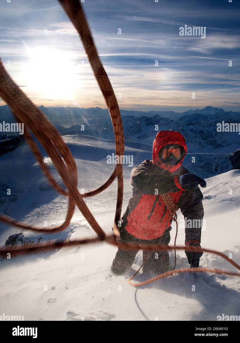 An Alpinist is throwing a rope towards his climbing partner Stock Photo ...