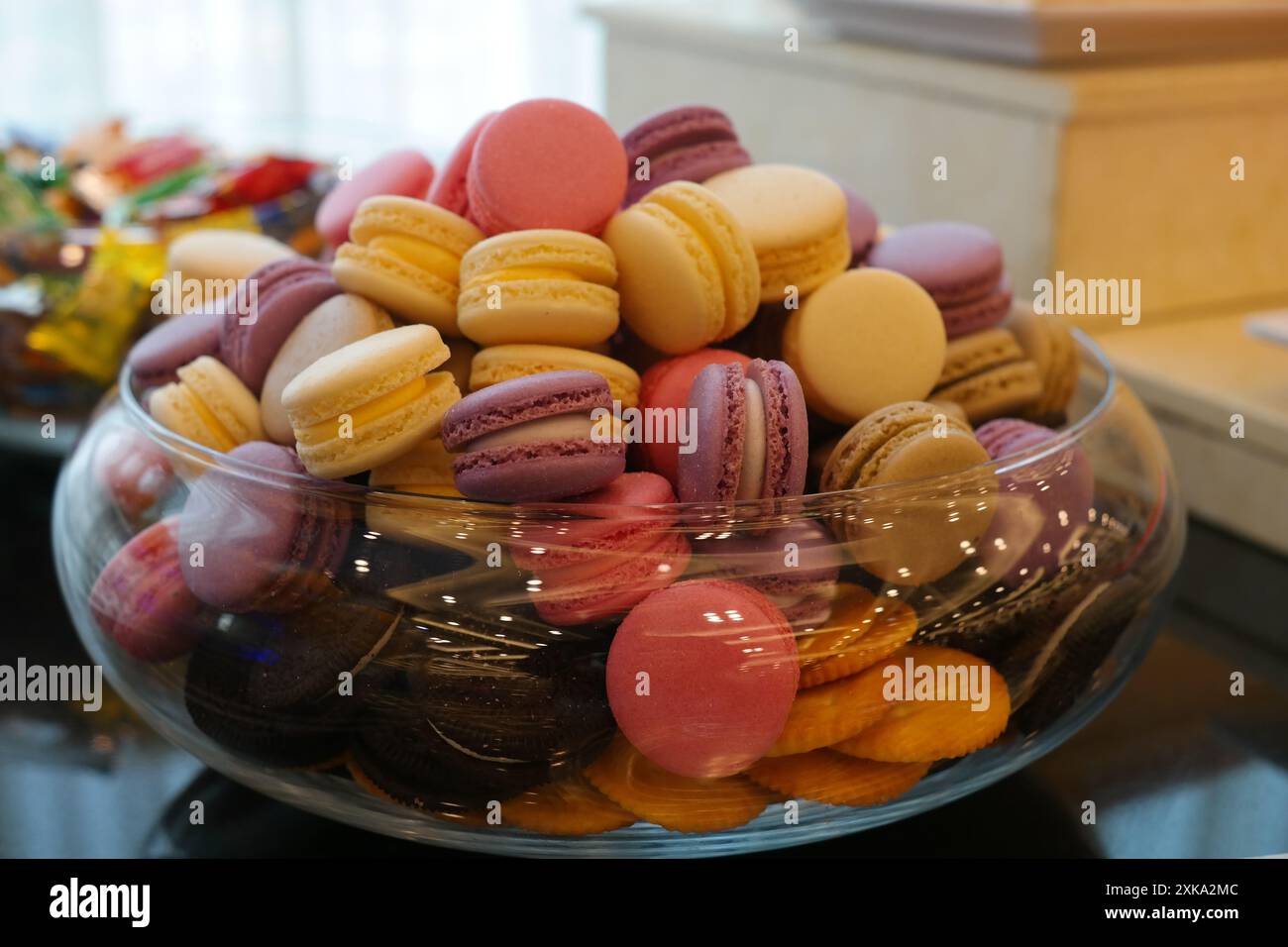 Assorted macaroons in a glass bowl on a table. Stock Photo