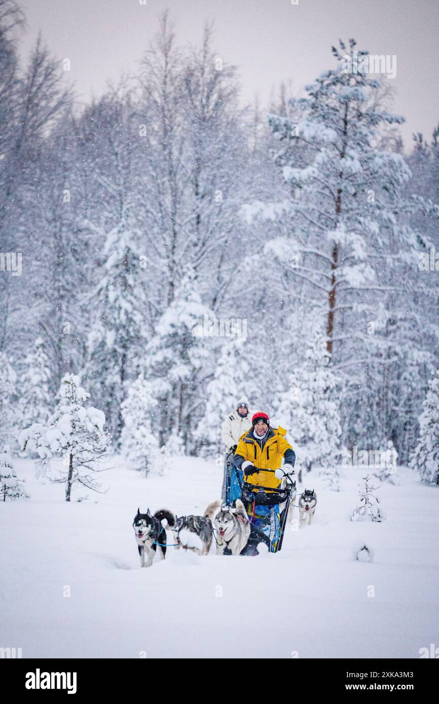 Happy man with daughter having fun dog sledding in the snow Stock Photo