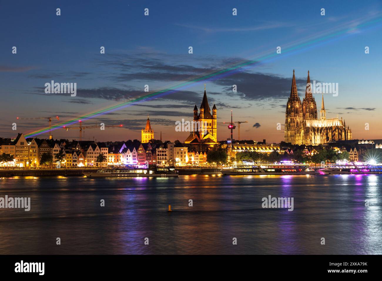 during Christopher Street Day 2024, a laser rainbow shines over the Rhine and the city centre of Cologne, Germany. Old town bank of the Rhine with tow Stock Photo