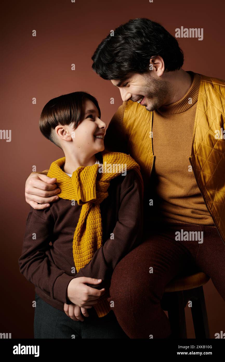 A man sitting next to a little boy, sharing a special father-son moment ...
