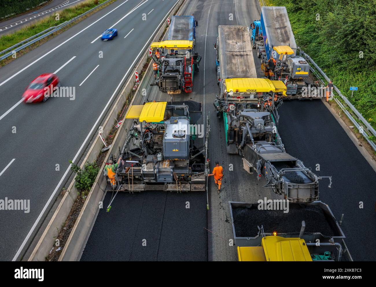 Essen, North Rhine-Westphalia, Germany - Road construction, asphalt pavers and road rollers are laying new, open-pored, fluester asphalt on the A52 mo Stock Photo