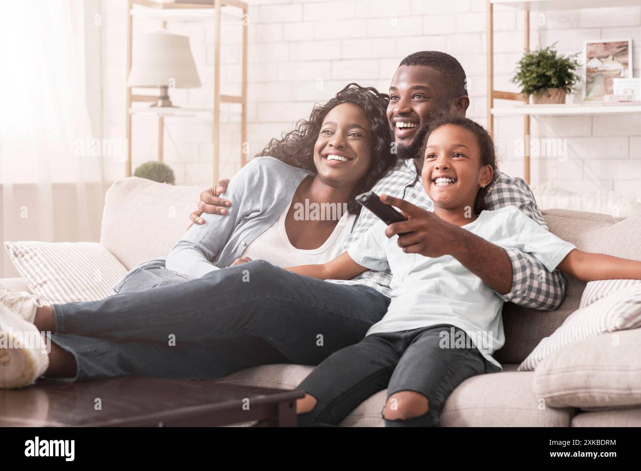 Happy black family relaxing and watching tv at home Stock Photo - Alamy