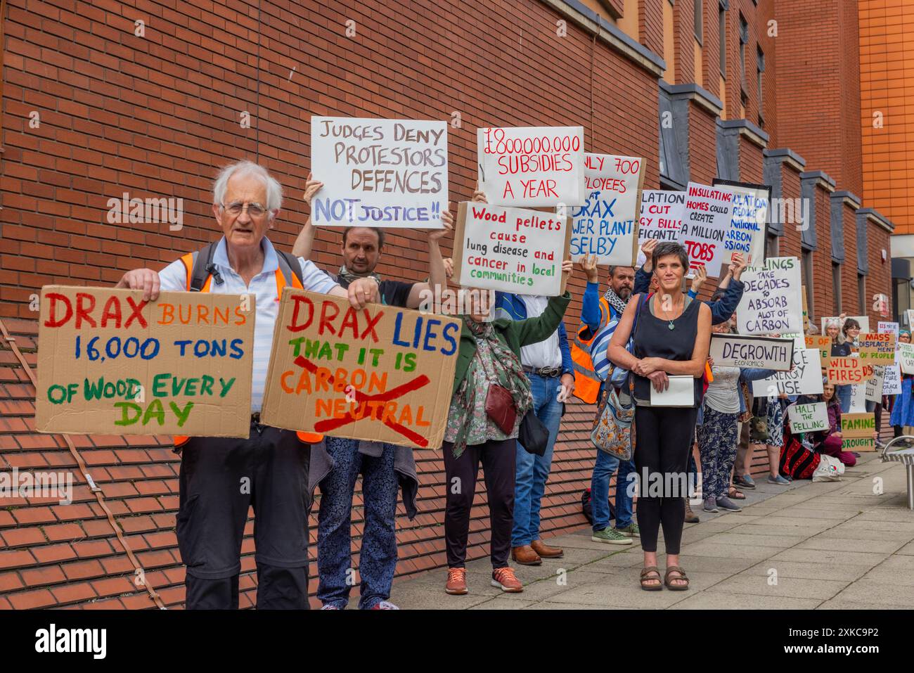 Leeds, UK. 22 JUL, 2024. Multiple activists hold placards outside Leeds Crown Court following the sentencing of Axe Drax Activist Karen 'Coffee' Wildin regarding there part in a protest in which a train towards Drax powerstation was stopped. The activist was given a conditional discharge and made to pay court fees. Credit Milo Chandler/Alamy Live News Stock Photo