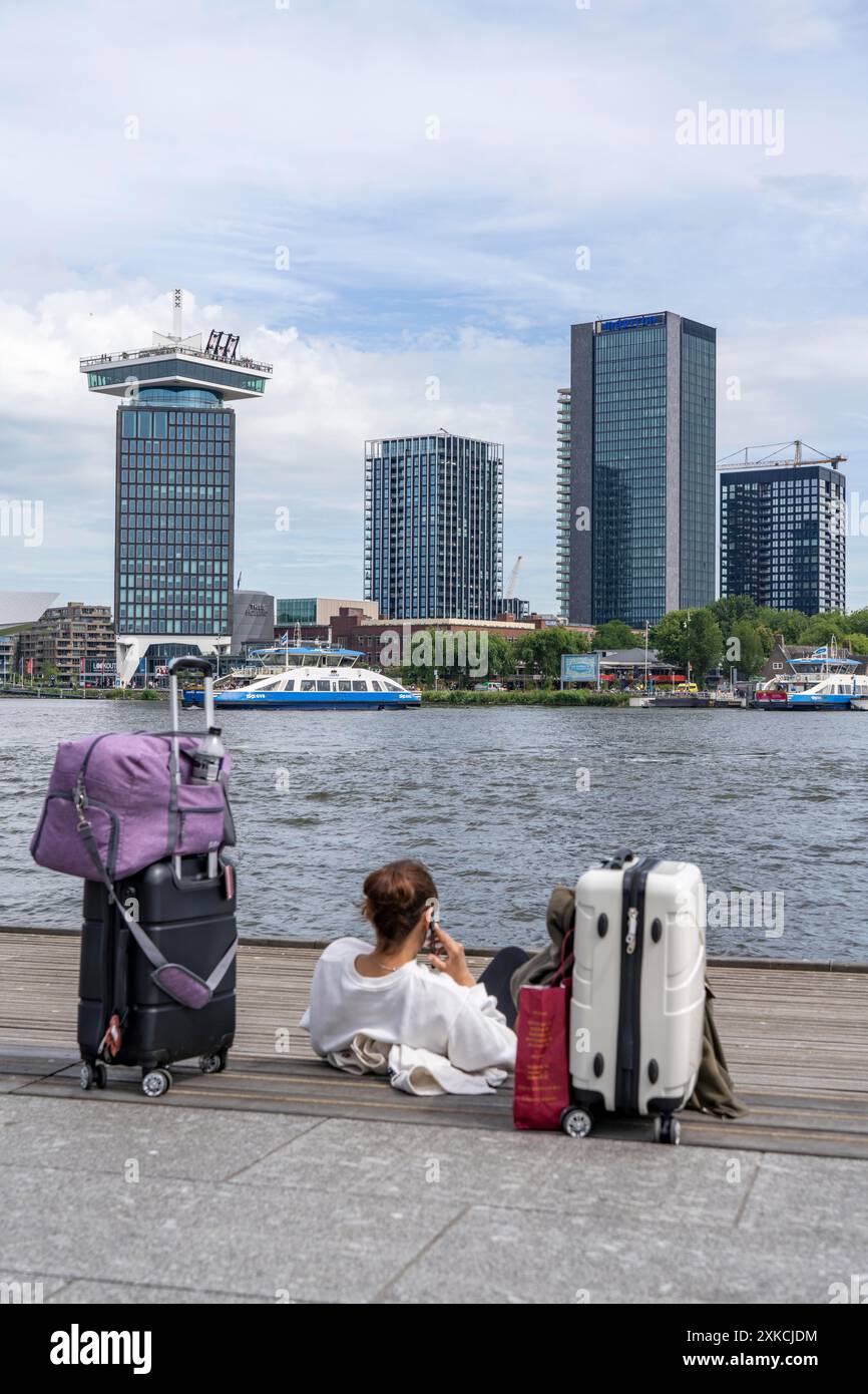 Tourists sitting at the back of Amsterdam Centraal station, on the ...