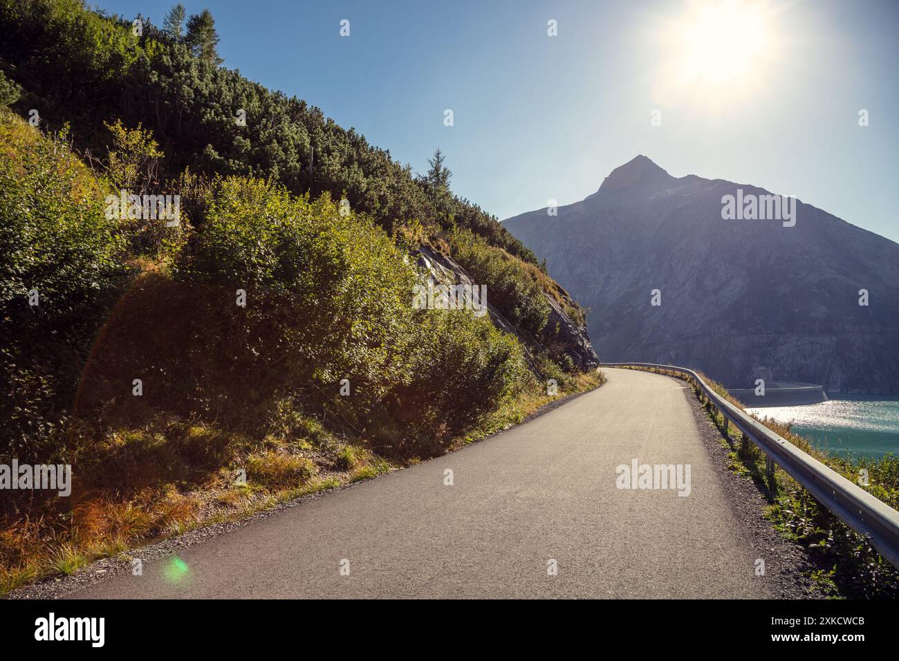 Driving a car on a mountain road along a beautiful mountain lake on a sunny day. Koelnbrein storage. Koelnbrein dam. Brandstatt, Austria Stock Photo