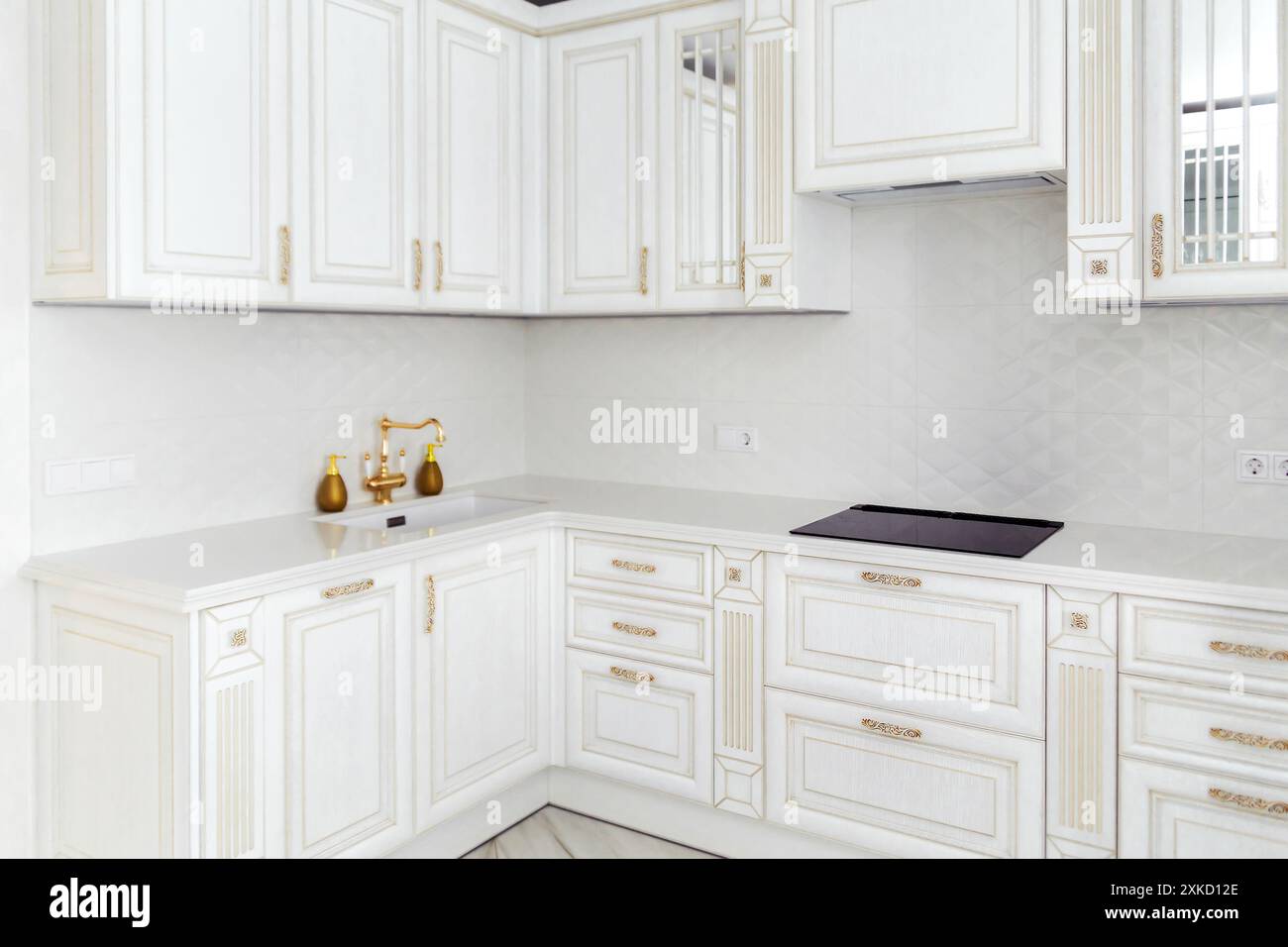 Elegant white kitchen with gold accents and modern cabinets. Captured ...