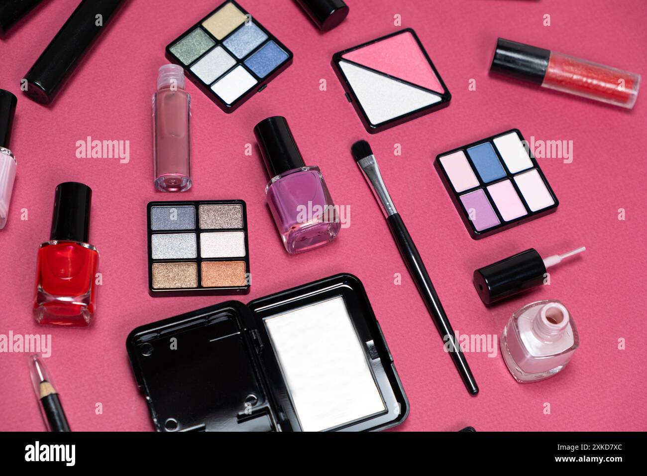 Various decorative cosmetics and brushes on a pink background. Stock Photo