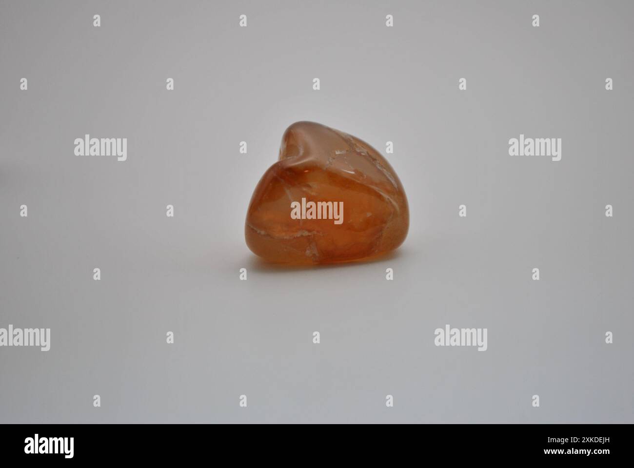 Smooth Tumbled Tangerine Quartz on White Background Stock Photo