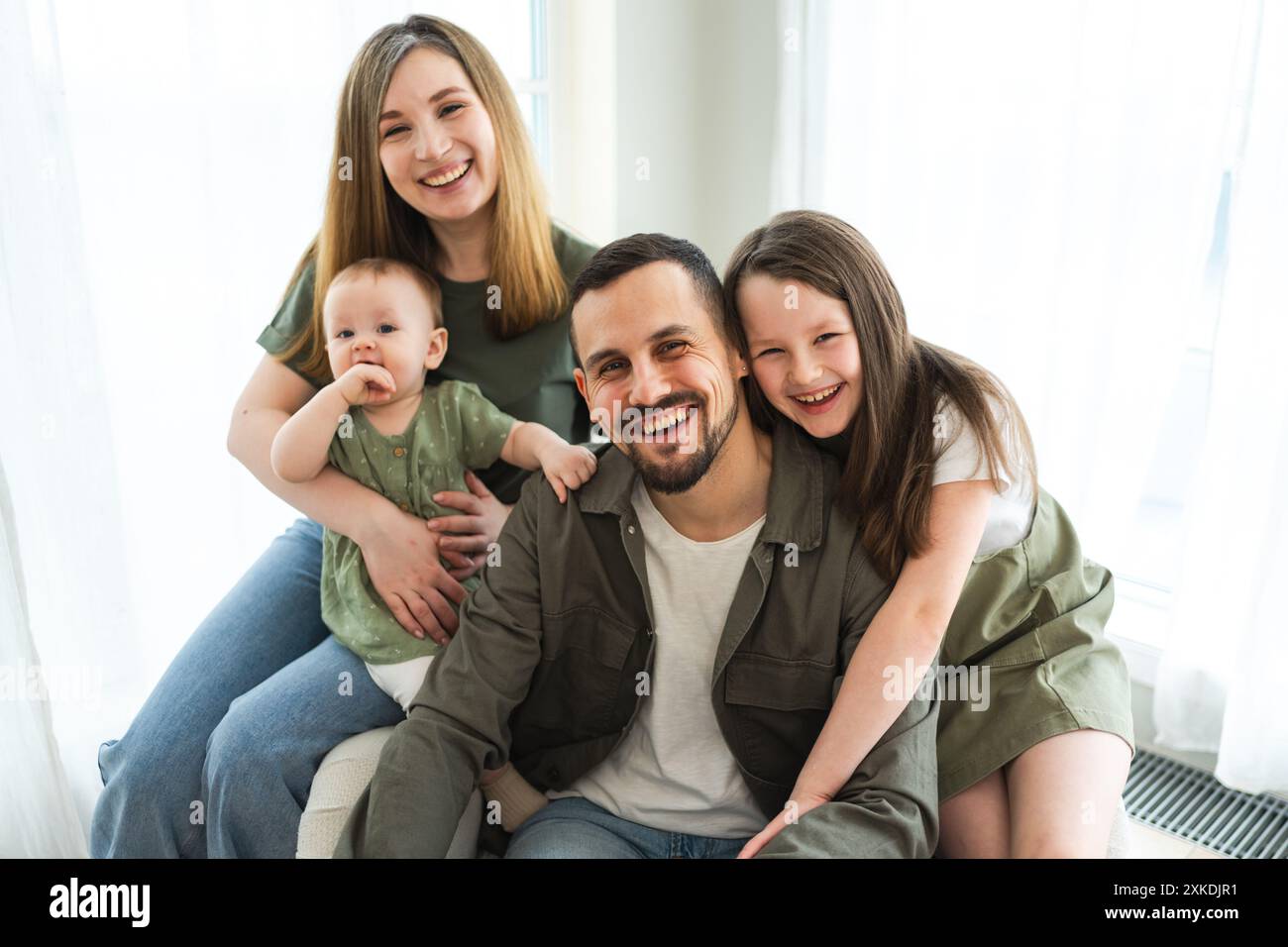 happy-family-at-home-mother-father-two-children-daughters-relaxing