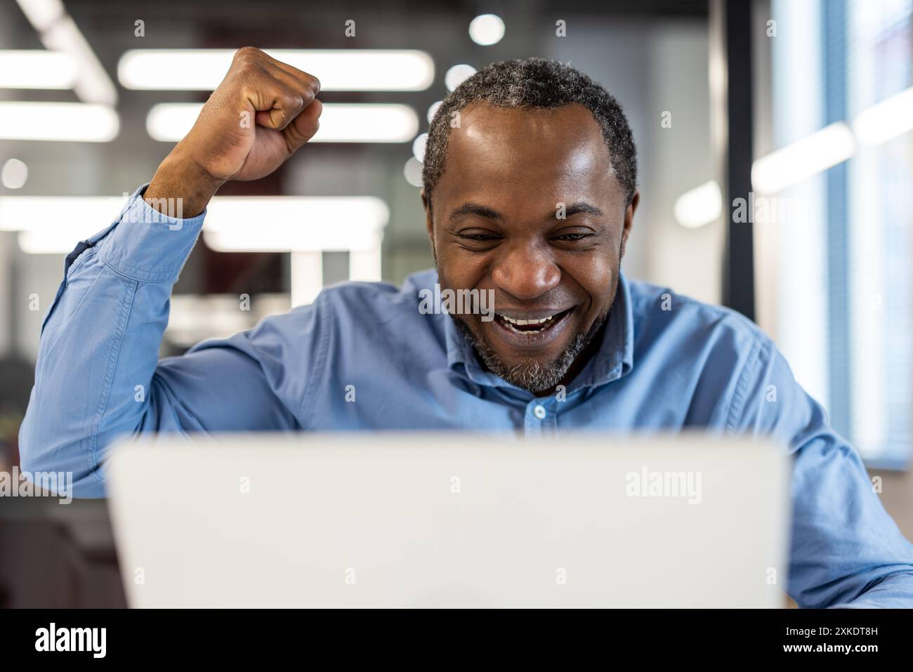 Happy businessman excitedly celebrating achievement with fist pump in ...