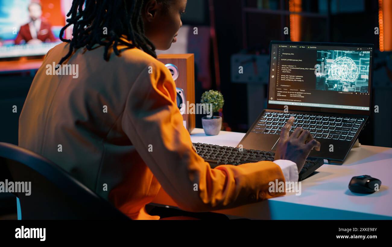 African american girl uses artificial intelligence software for machine learning and cloud computing, terminal window programming language. IT student studying deep learning AI hardware. Camera A. Stock Photo